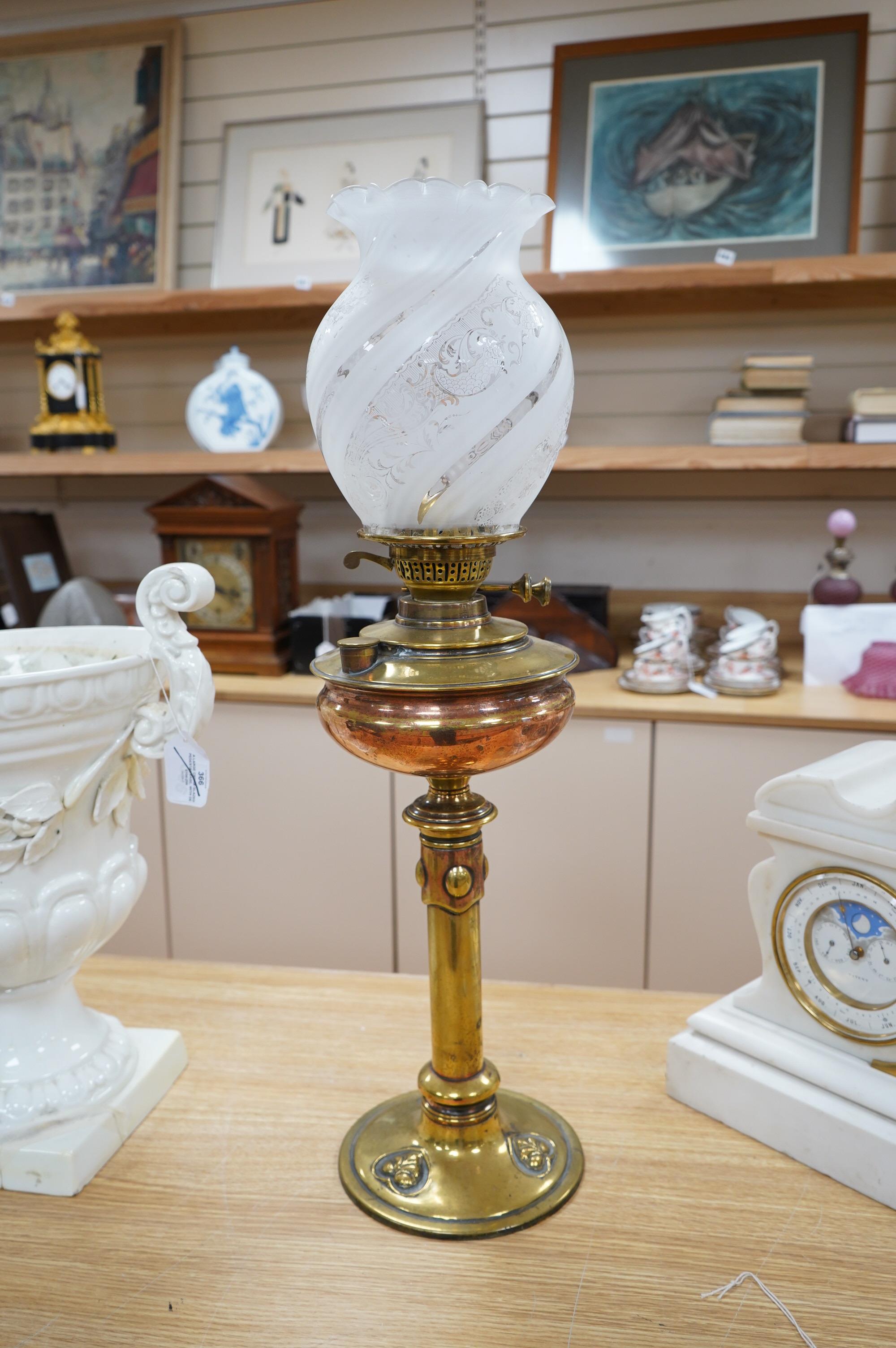 An English Arts and Crafts oil lamp with frosted acid etched shade, chimney, overall 74cm high. Condition – areas of old copper plating showing otherwise in good condition